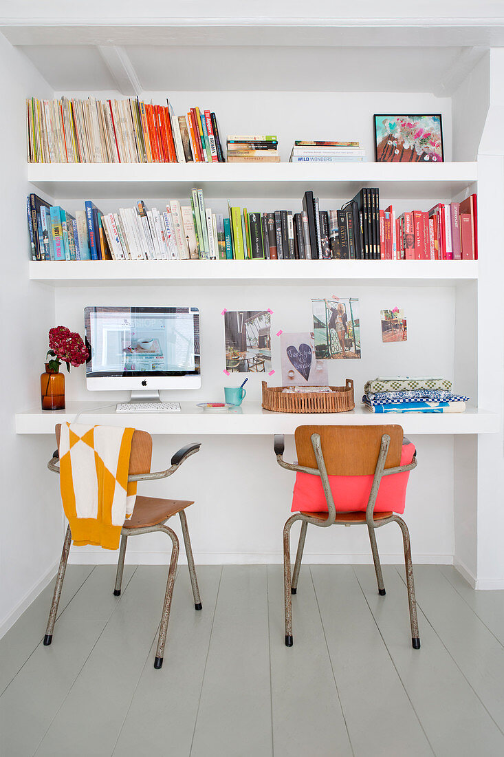 Vintage chairs in front of floating desk and shelves in niche