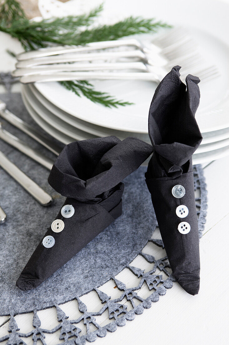Black paper napkin folded in the shape of a boot