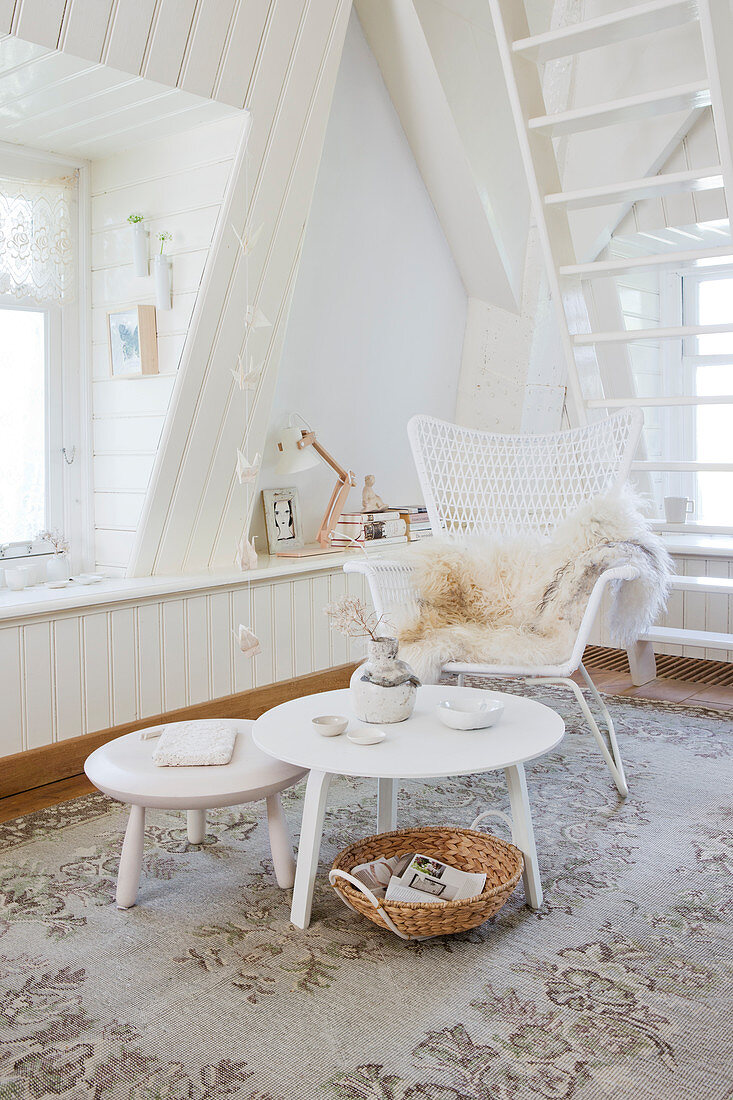 Rattan armchair and placemat in a white room with a dormer window