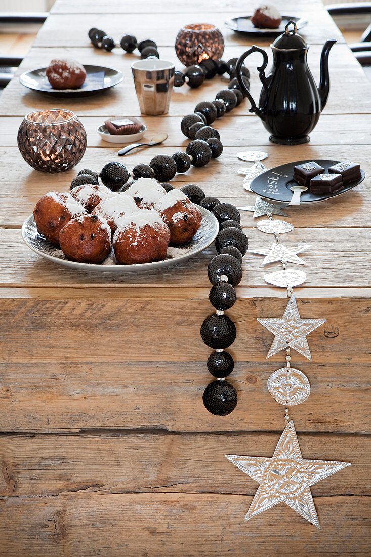 Winterliche Deko mit schwarzer Perlenkette auf rustikalem Holztisch