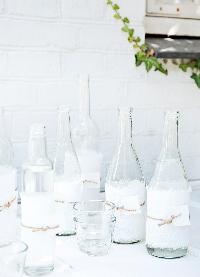 Clear glass bottles wrapped in torn fabric