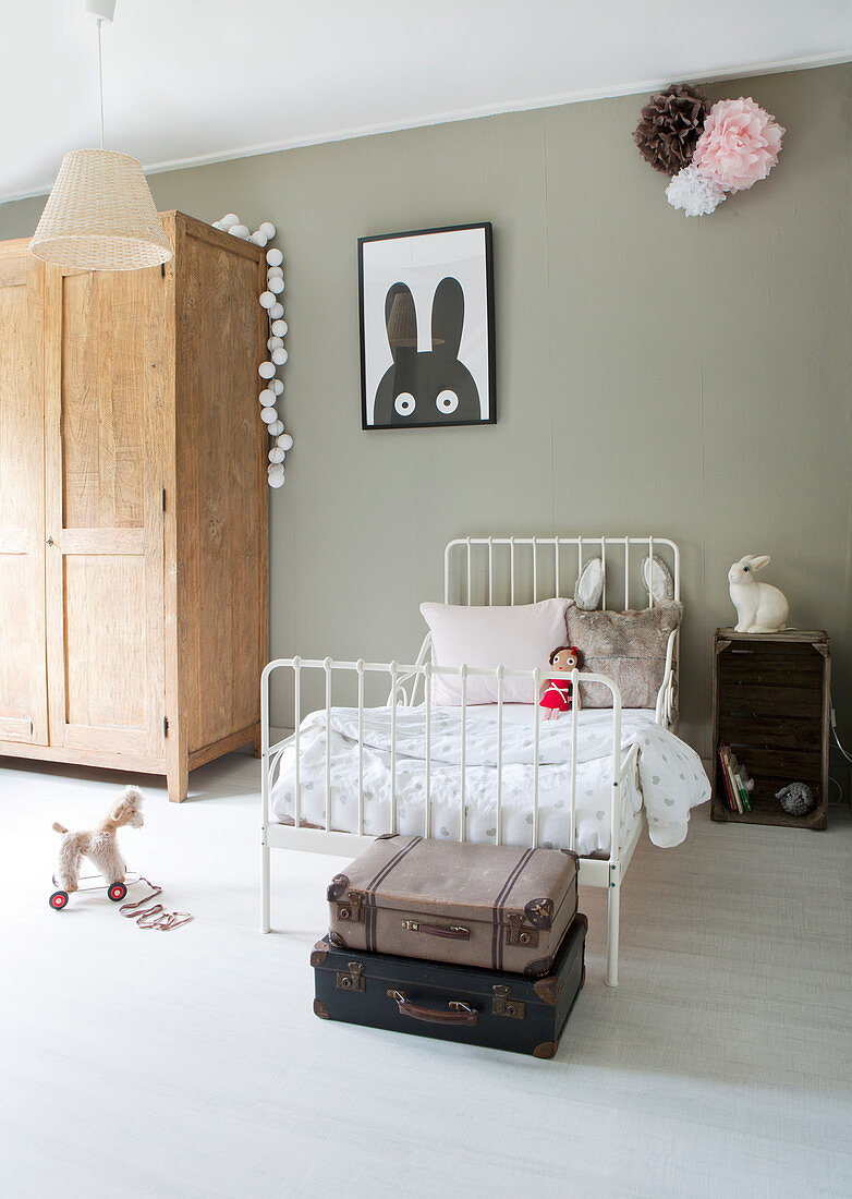 Nostalgic metal bed in the children's room with a gray wall