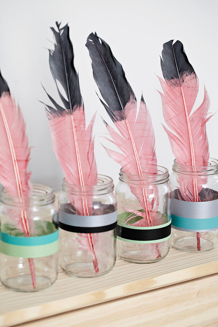 color dipped Pink feathers in screw jars with washi tape
