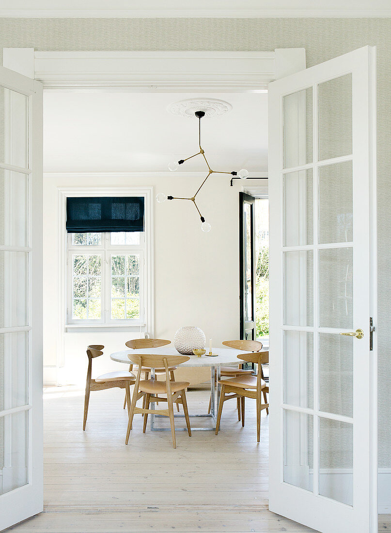 looking through the open glass door into the bright, Scandinavian-style dining room