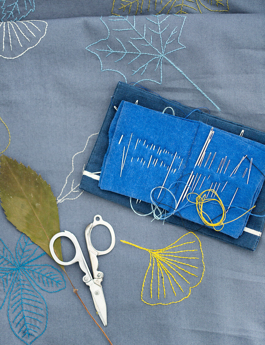 Embroidered cloth with autumn leaves, scissors and a sewing needle case