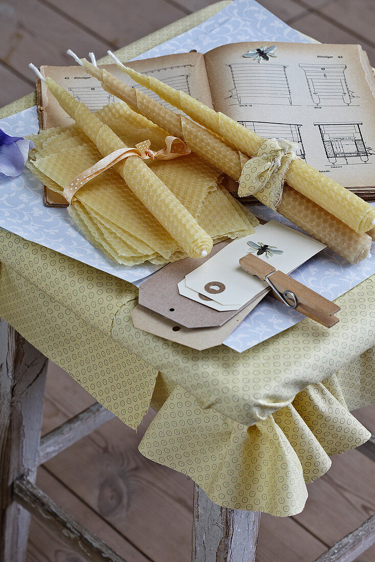 Candles rolled from beeswax sheets, beekeeping books and paper tags
