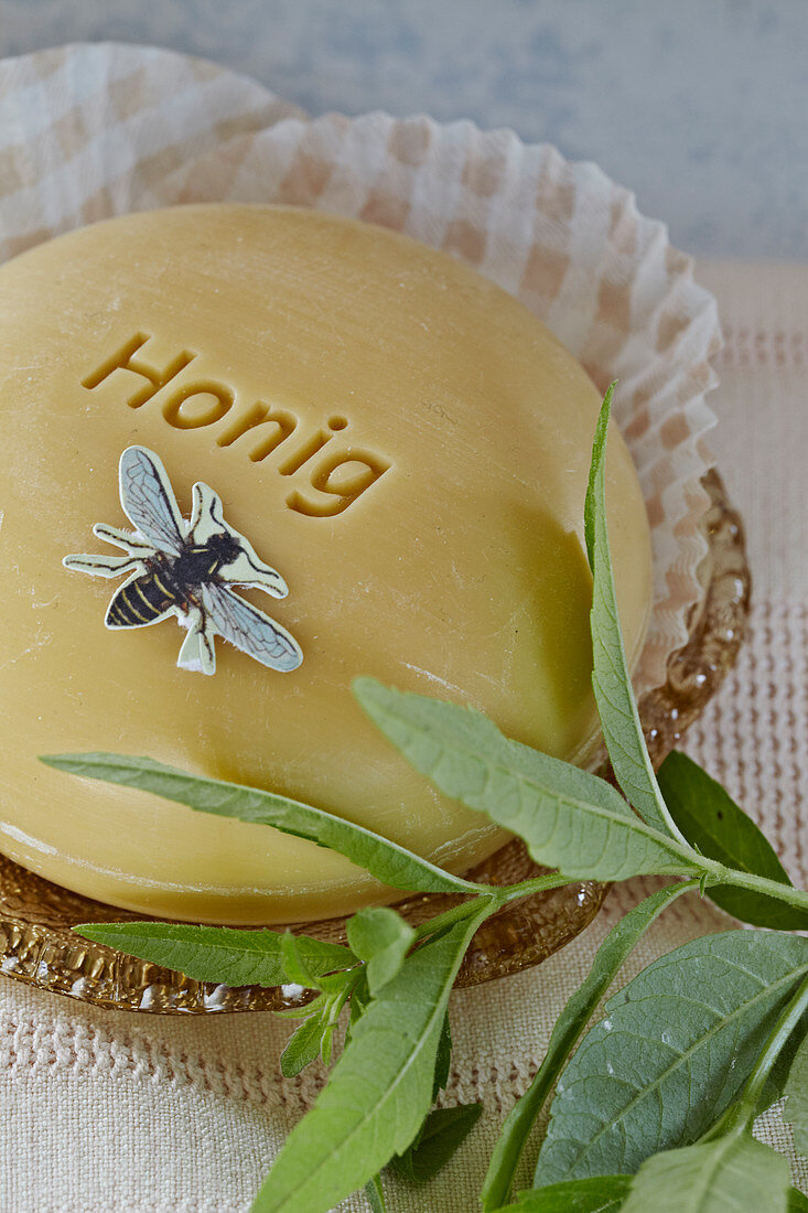 Seife aus Honig mit einer Biene aus Papier und Verbenenzweig