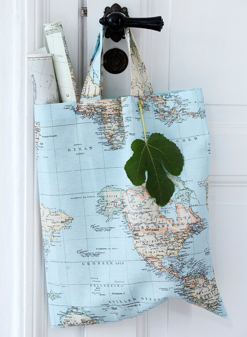 Fabric bag with a world map motif and rolled up maps