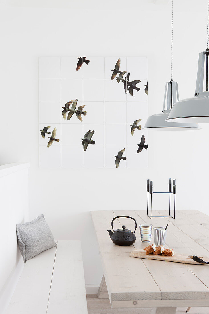 Wall decoration with a bird motif above the light wooden table