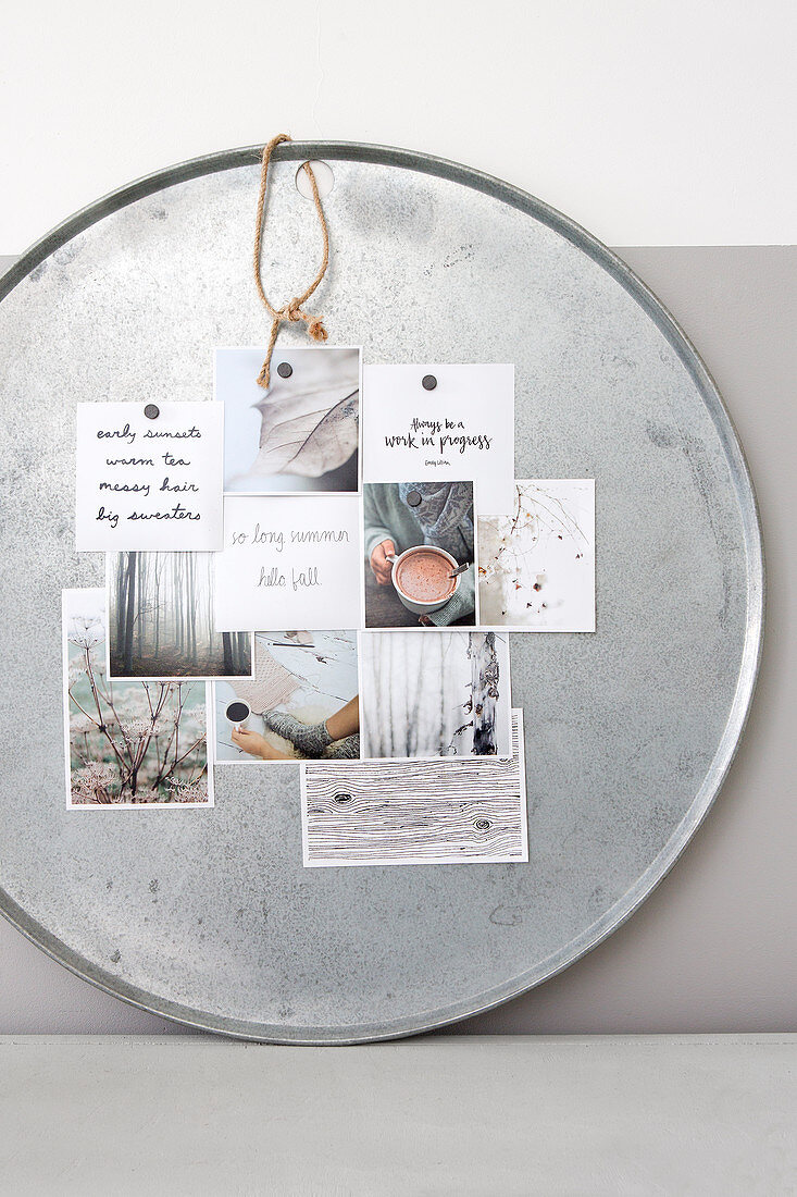 A silver metal tray as a pinboard with winter postcards