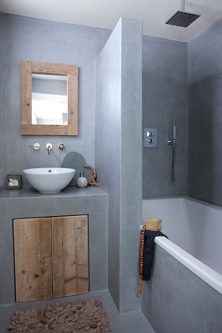 Rustic bathroom in gray with built-in tub and vanity with wooden door