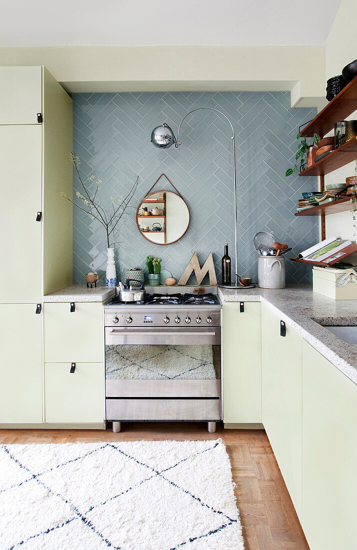 Einbauküche über Eck und blaue Wandfliesen in offener Küche