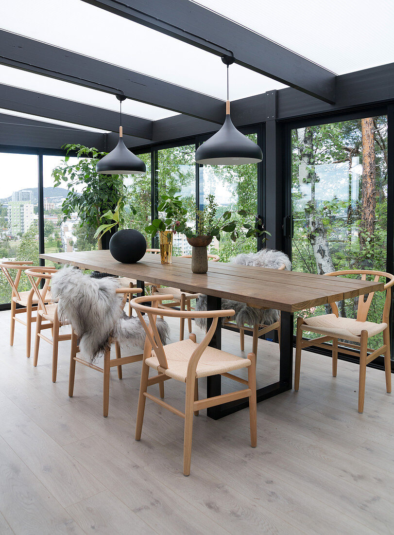 Self-made wooden dining table with classic chairs in the winter garden