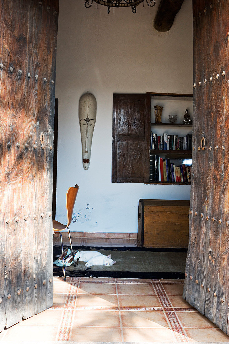 Blick durch offenes altes Holzportal ins mediterrane Haus