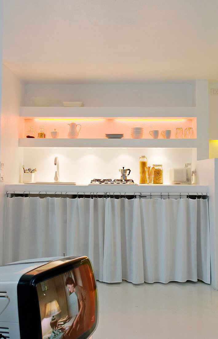 Curtains as fronts in a small kitchen with brick shelves