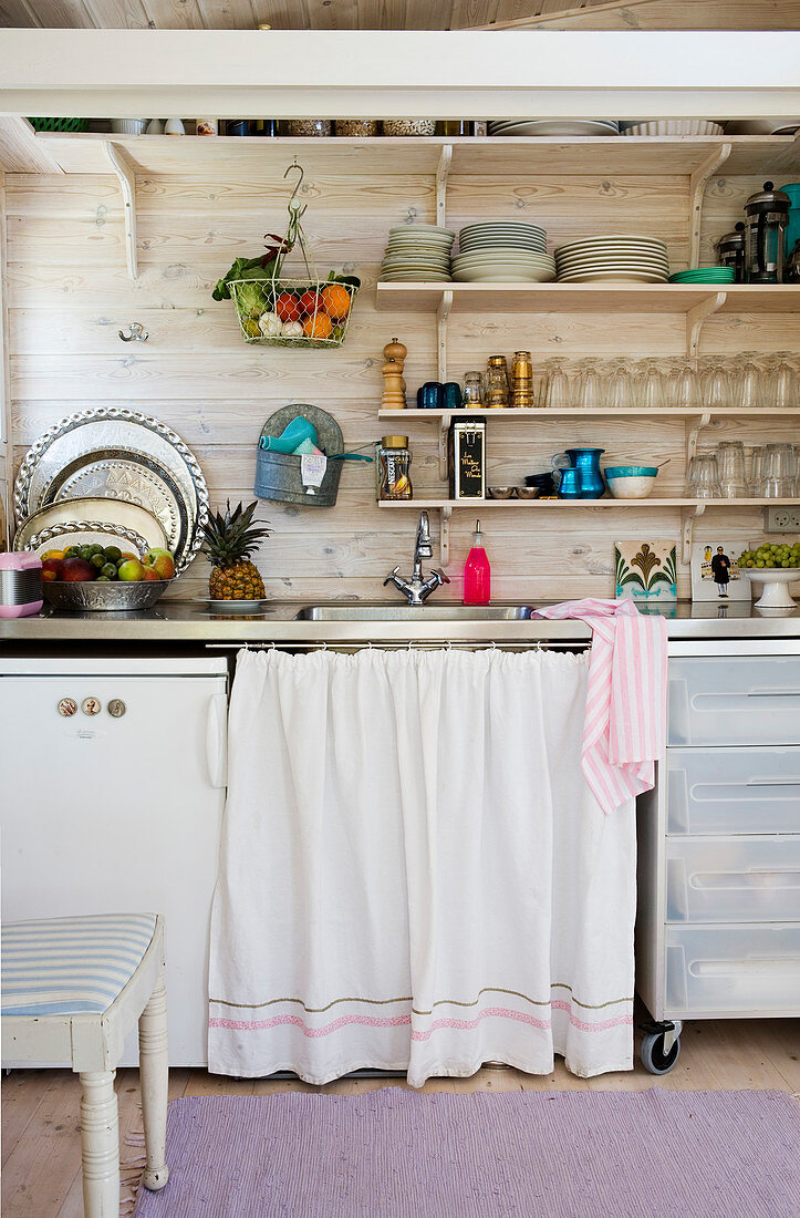 The curtain over the sink in a small kitchen with open shelves