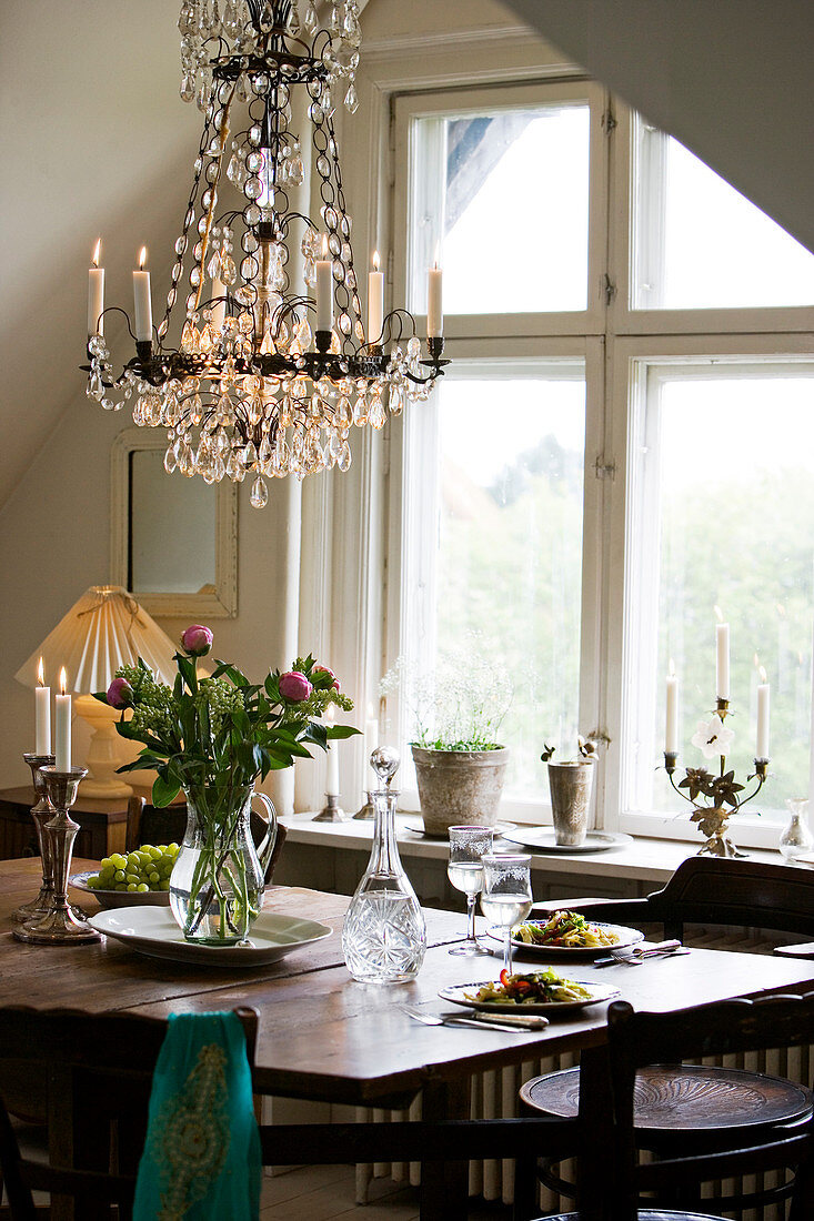 The chandelier above a classic, wooden table
