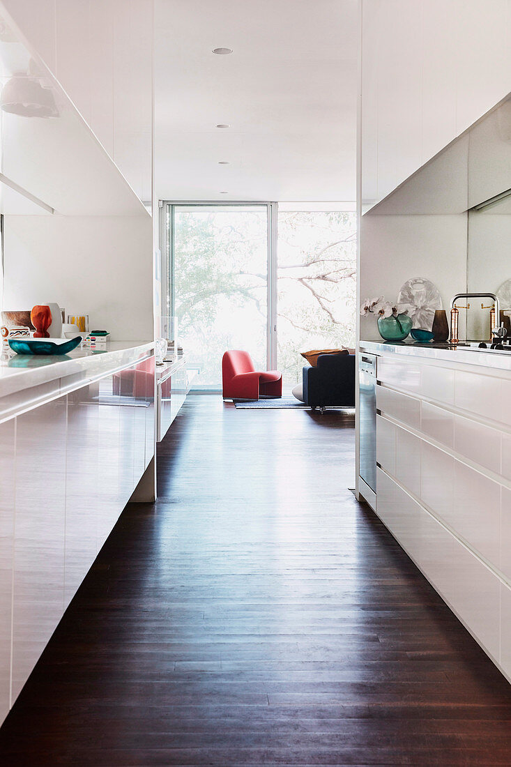 Blick aus der offenen Küche mit weißen Fronten ins Wohnzimmer