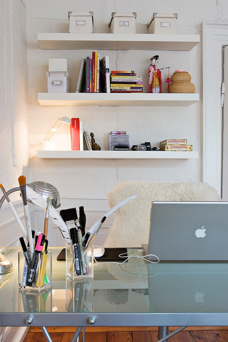 White shelves on the wall above the desk
