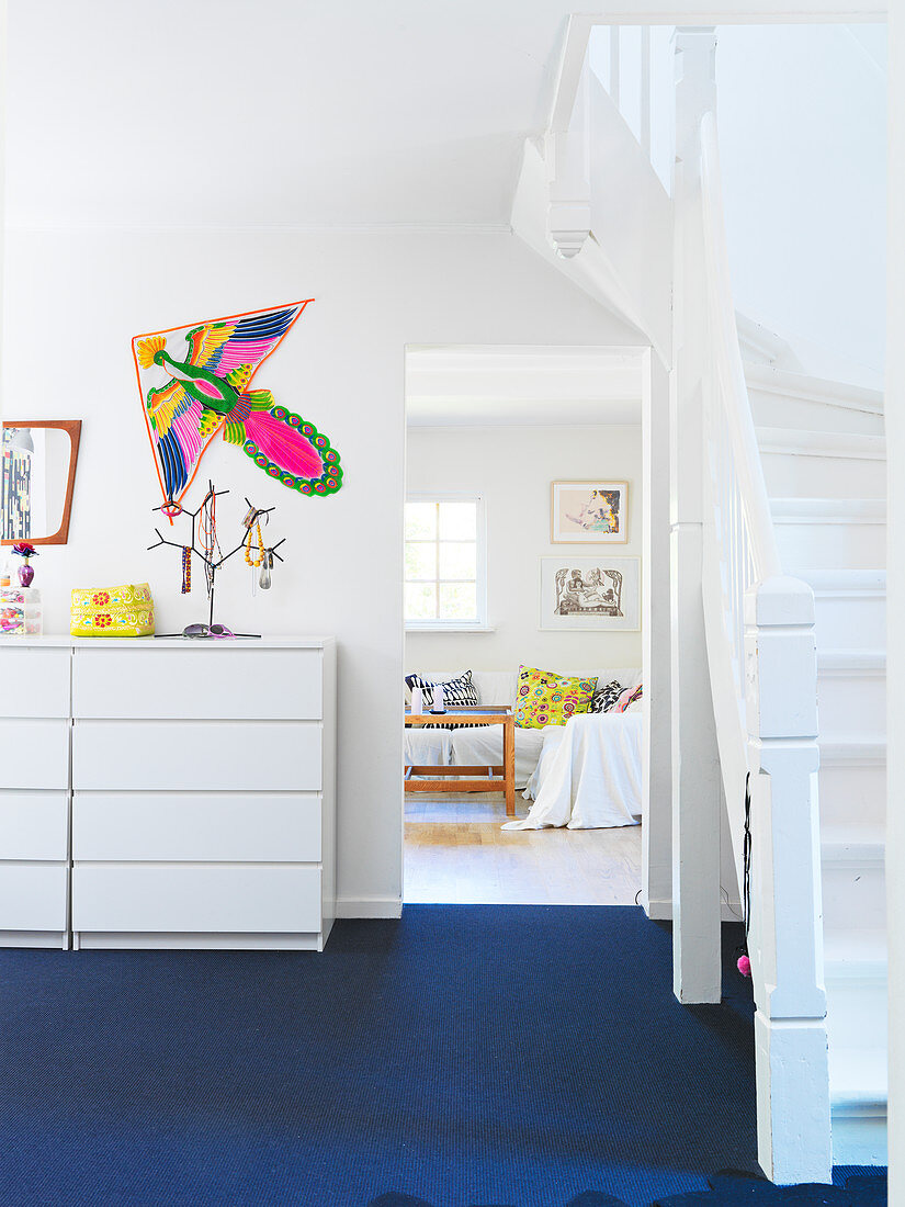 Flur mit blauem Boden, Treppe und Blick ins Wohnzimmer