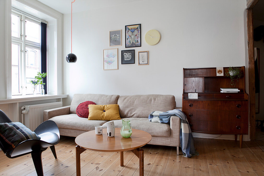 Antiker Sekretär, sandfarbene Couch, Coffeetable und Designerstuhl im Wohnzimmer