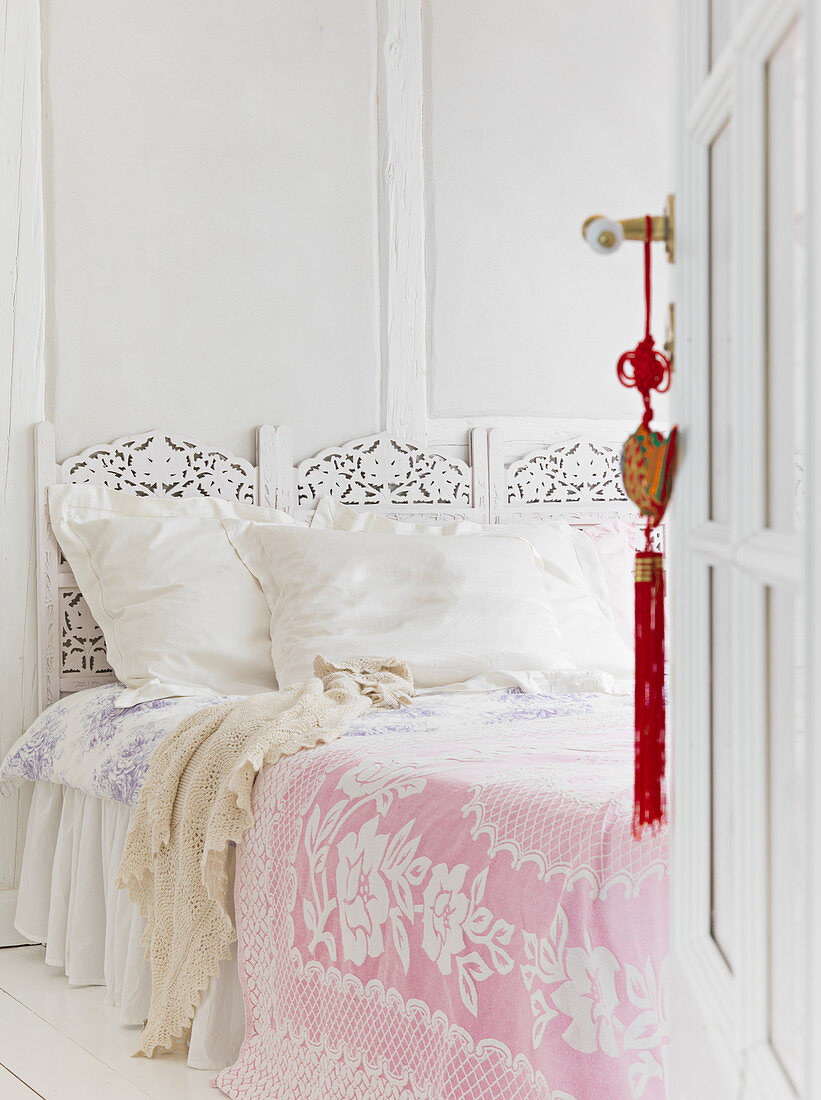 Offene Kassettentür zum Schlafzimmer mit romantischem Bett