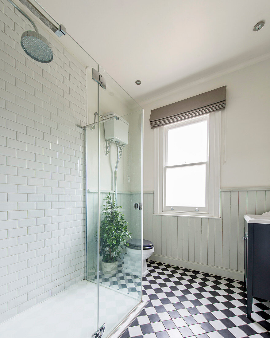 Classic bathroom with chequered floor, wainscoting and tiled shower area