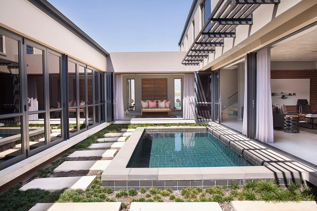 Pool in courtyard of modern house with open walls