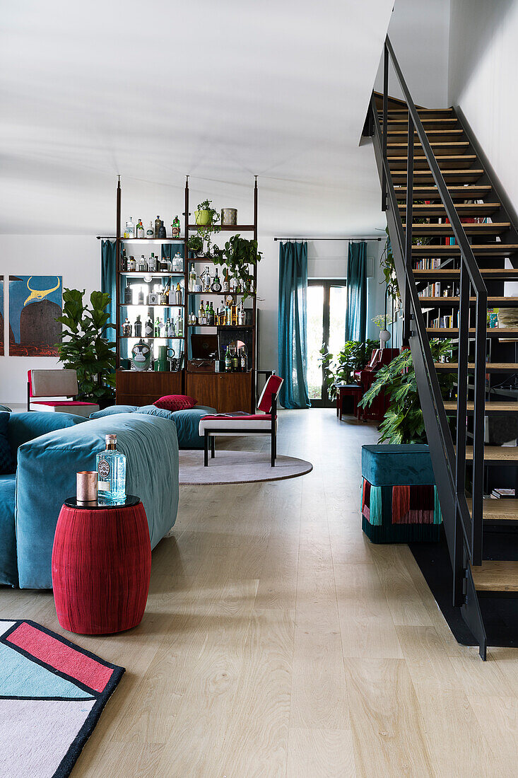 Black staircase in open-plan interior with blue and red accents