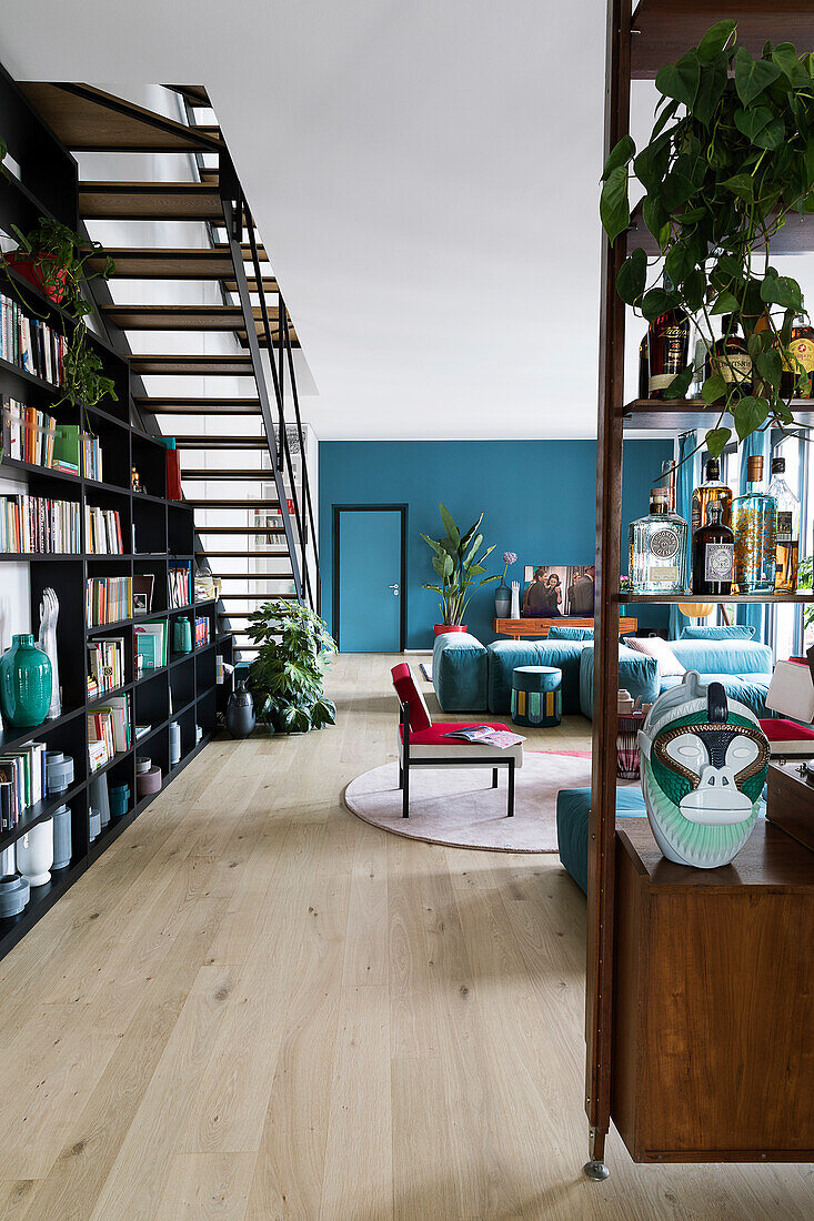 Open-plan interior with shelves used as partition and blue wall