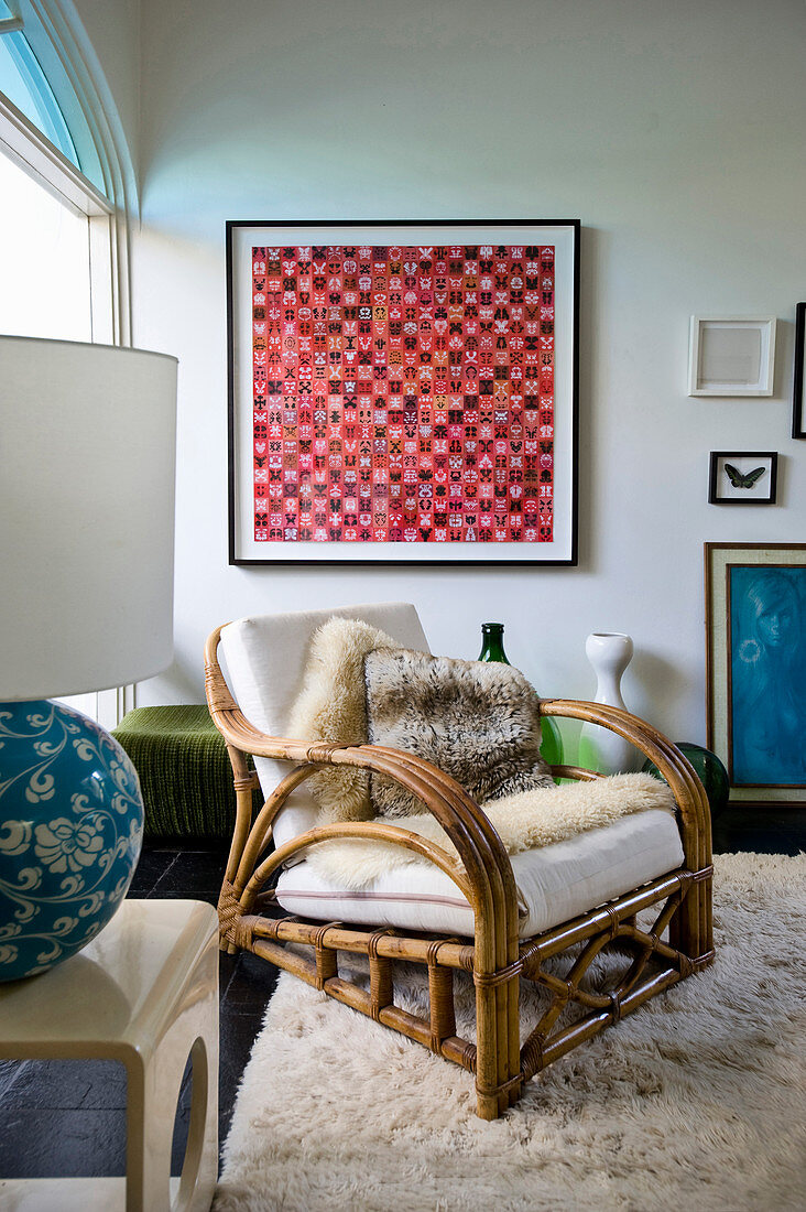 Rattan armchair in front of artwork and lamp on side table in living room