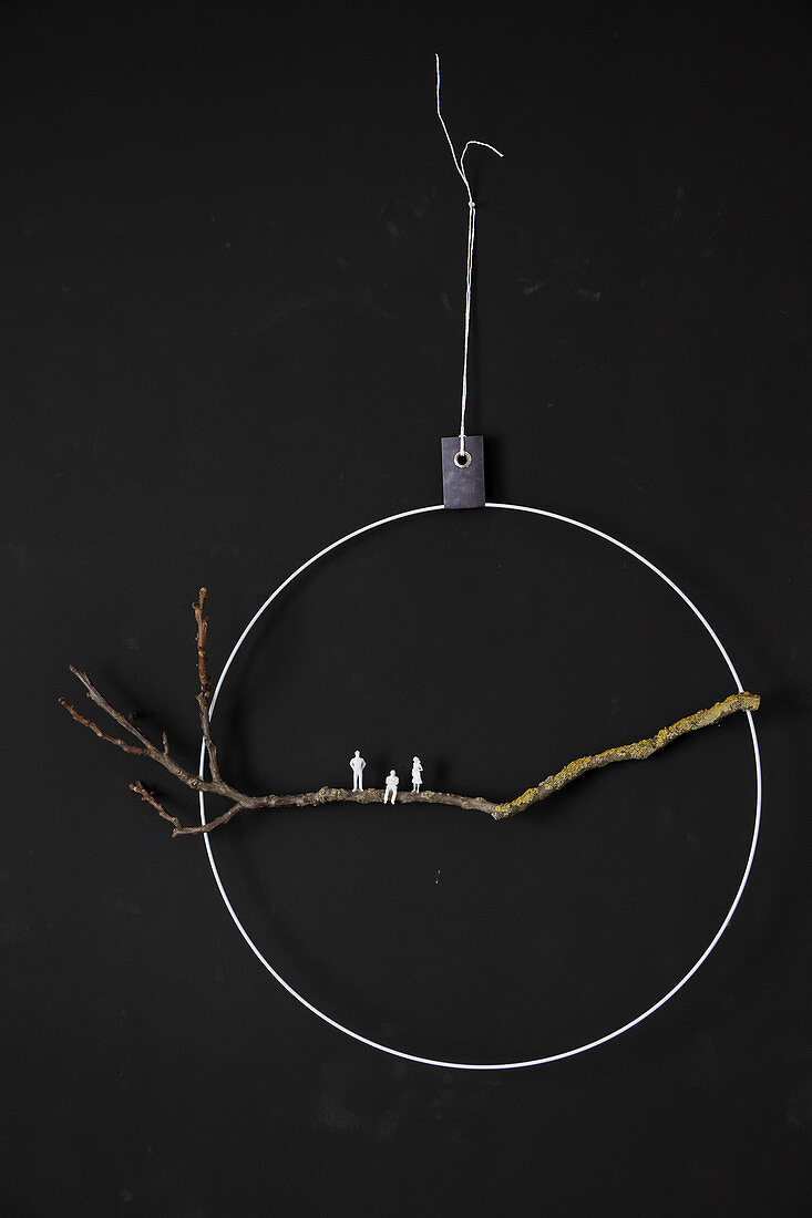 DIY wall decoration: twig and tiny figurines in metal ring