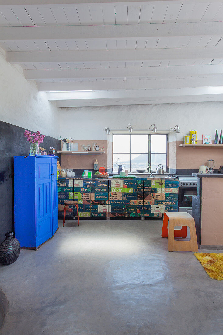Bright blue cupboard in Mediterranean kitchen with cabinets made from fruit crates