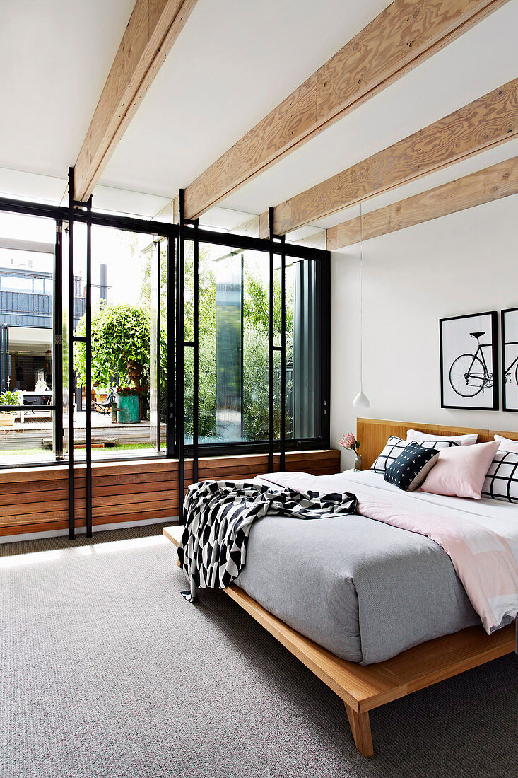Doppelbett in elegantem Schlafzimmer mit Fensterfront