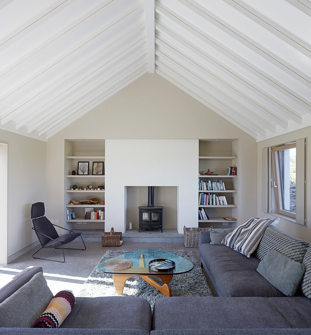 Wohnzimmer mit grauer Sofagarnitur, Coffeetable und Kamin