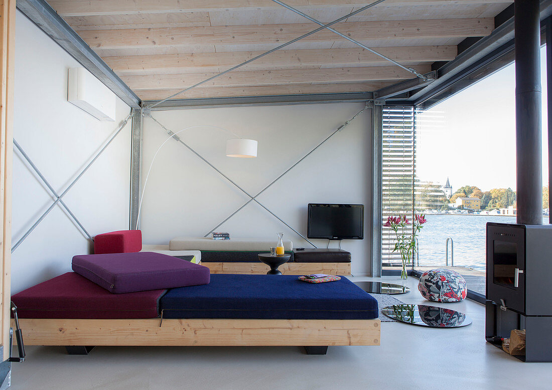 Modern houseboat: custom sofas, log burner and TV in living area