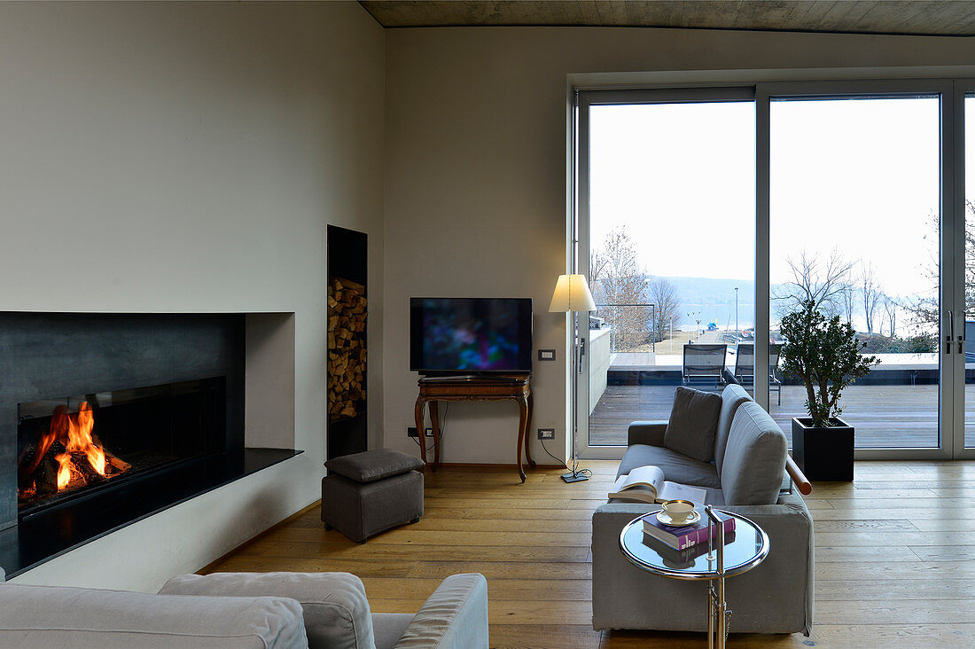 Seating area with fireplace and floor-to-ceiling sliding glass doors leading onto roof terrace