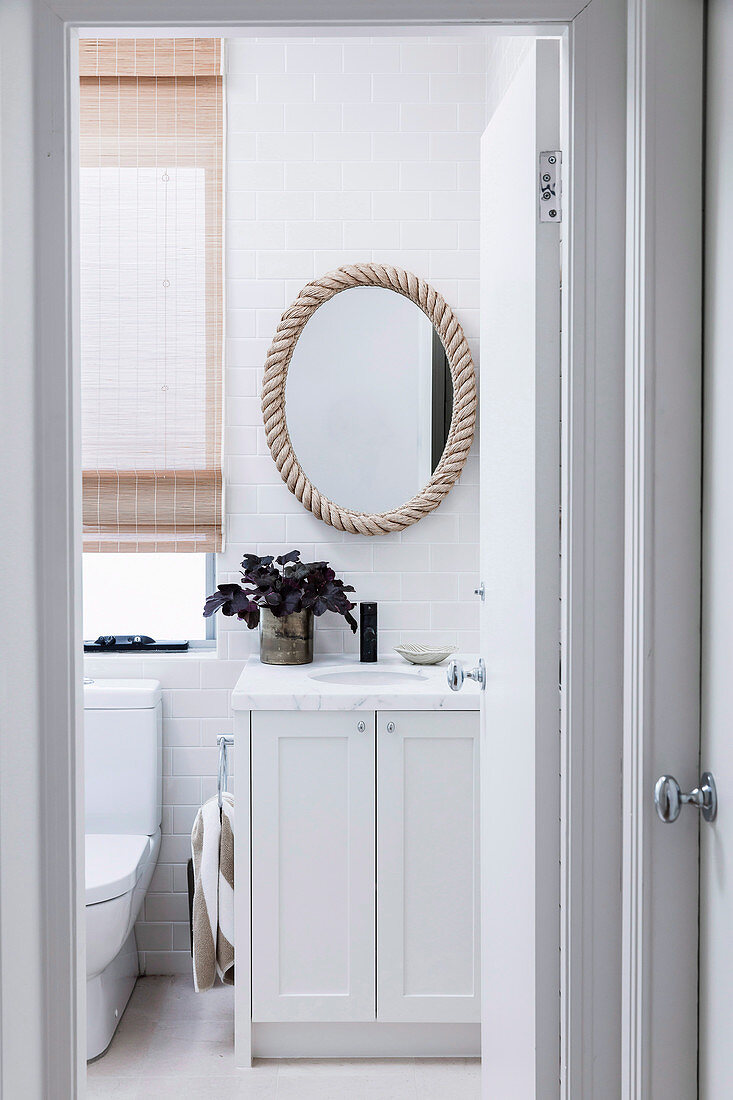 Glance into bright bathroom with vanity and toilet