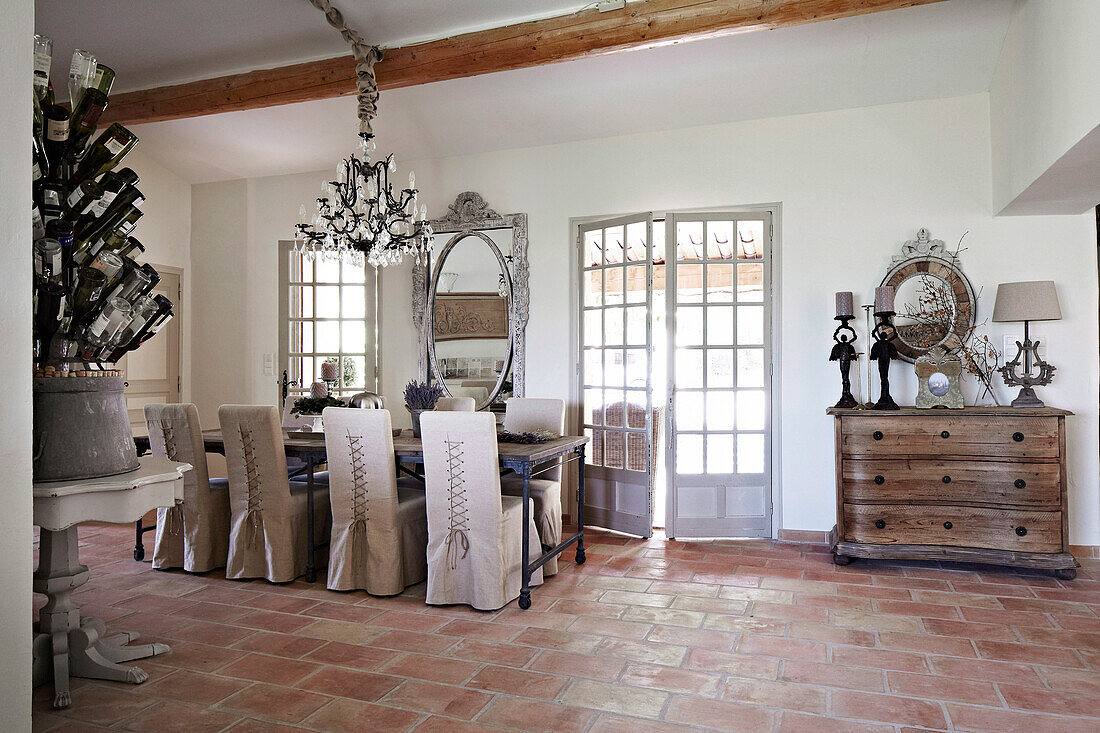 Dining table with hussen chairs and chandelier in a French country house