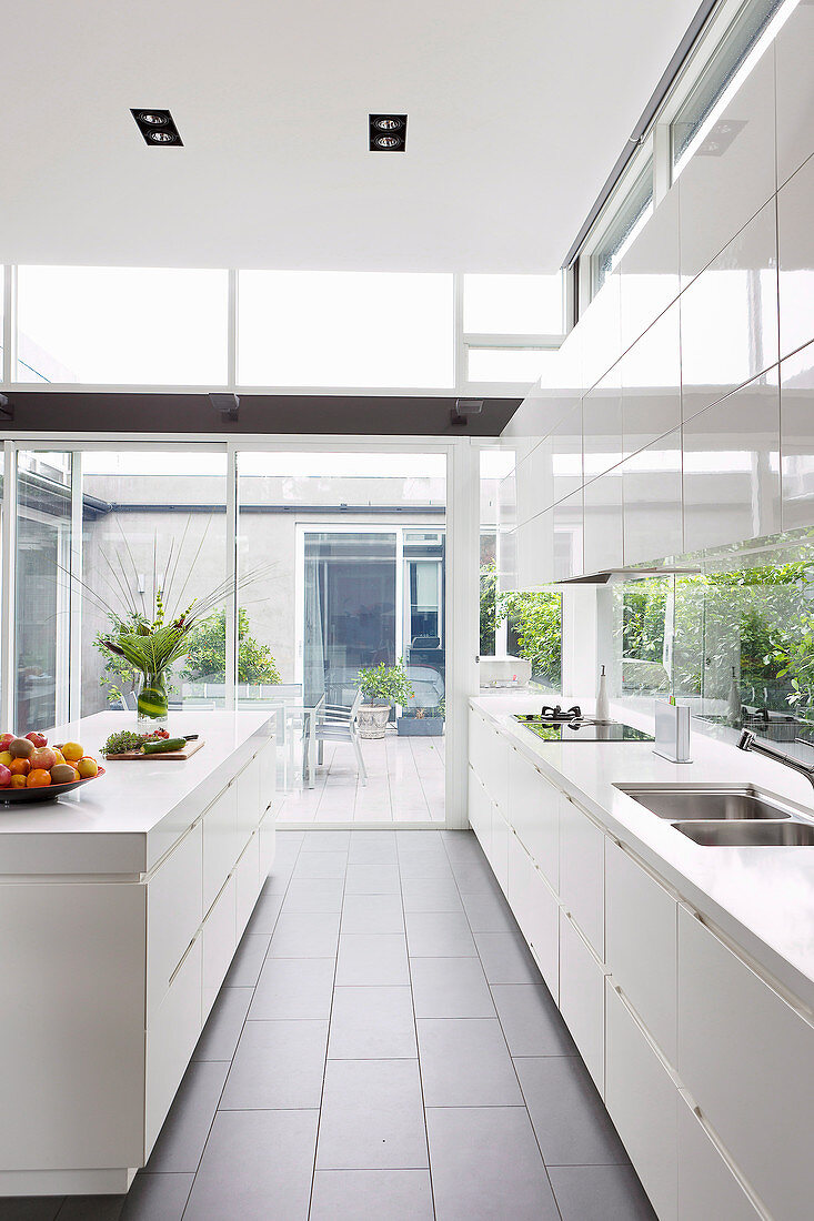 Weiße Hochglanz-Küche im Architektenhaus mit Fensterfronten