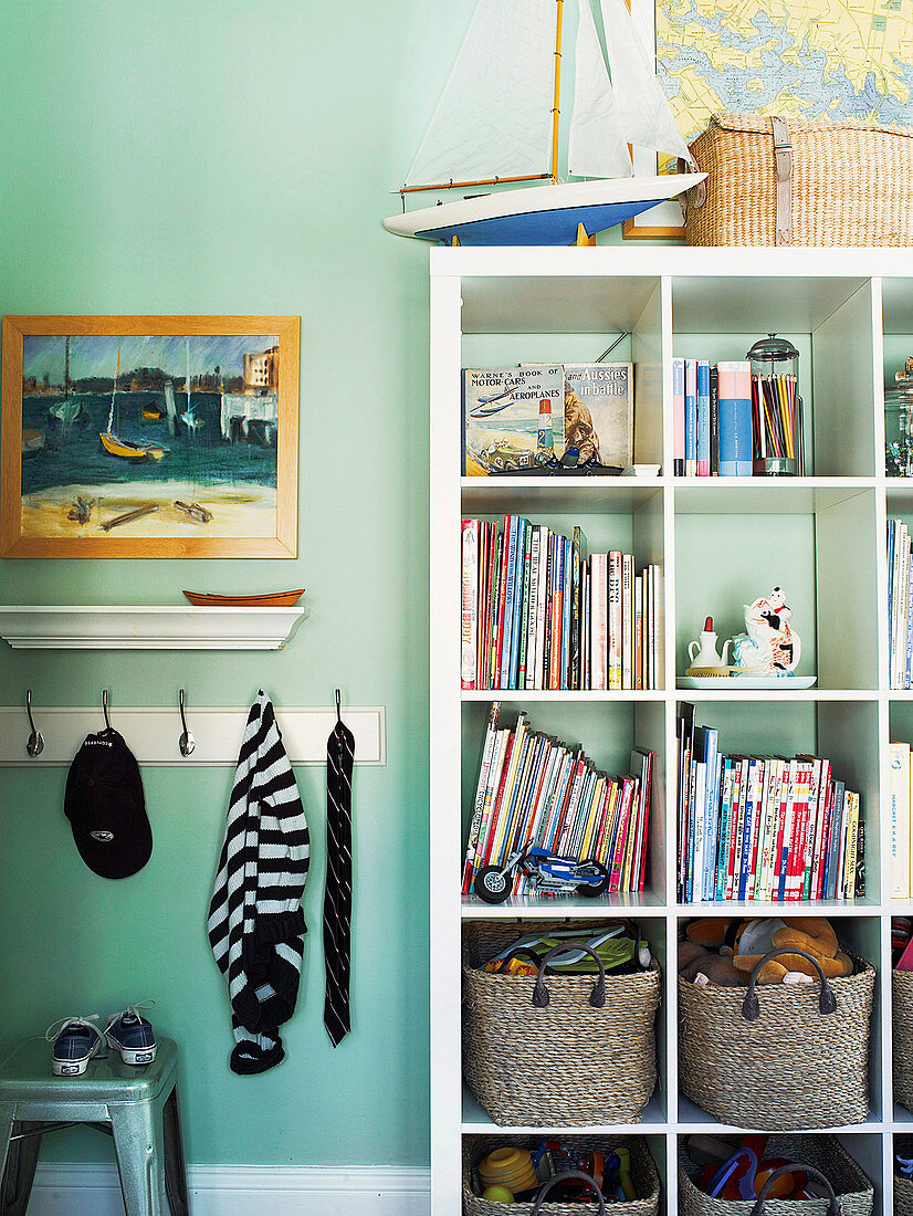 Open shelf on turquoise wall in boy's room
