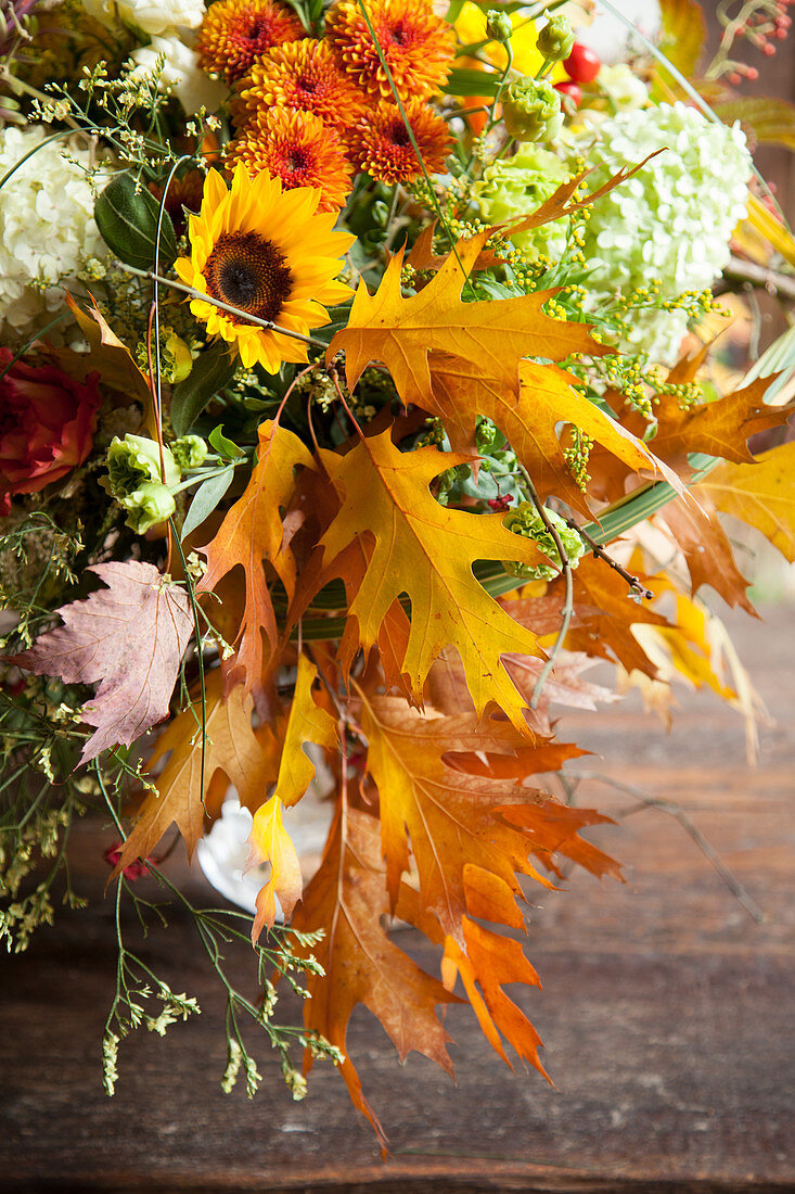 Üppiger Herbststrauß mit Hortensie, Chrysanthemen, Sonnenblumen und Eichenlaub