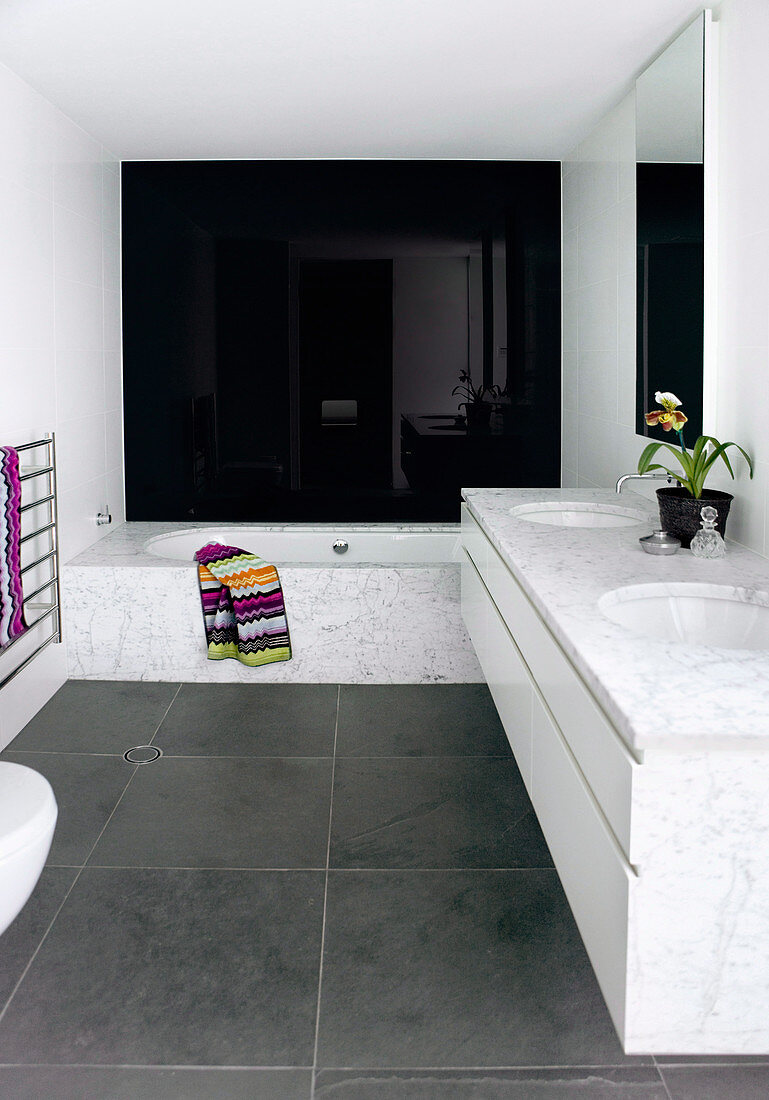 Modern bathroom with marble and high-gloss black wall