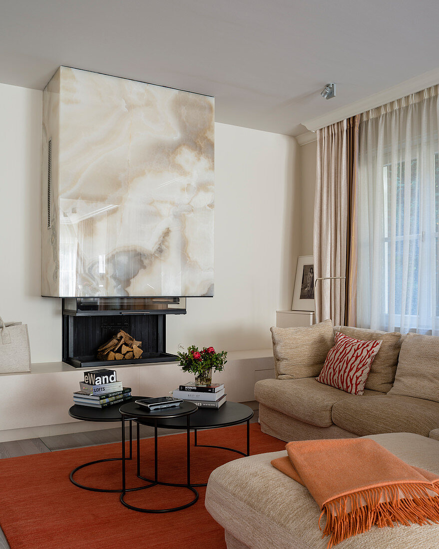 Fireplace with onyx chimney breast in living room decorated in beige and orange