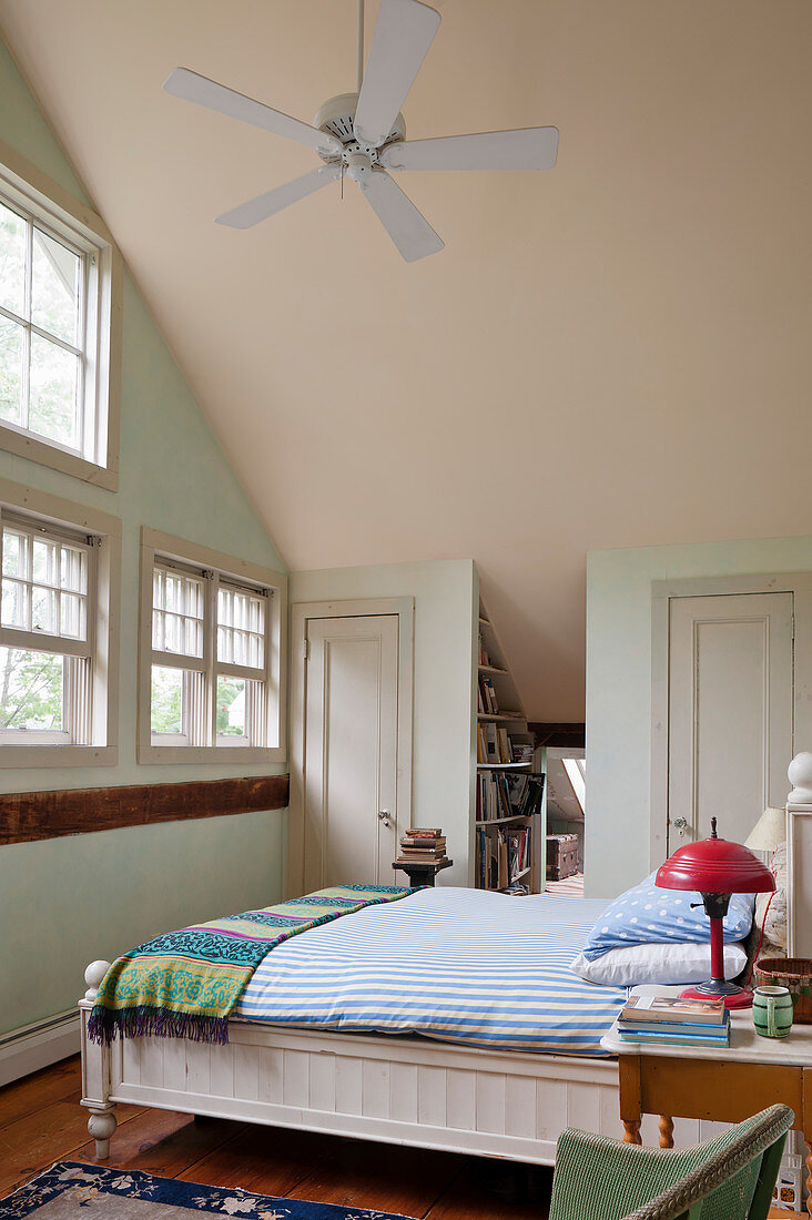 Bedroom with high, sloping ceiling in country-house style