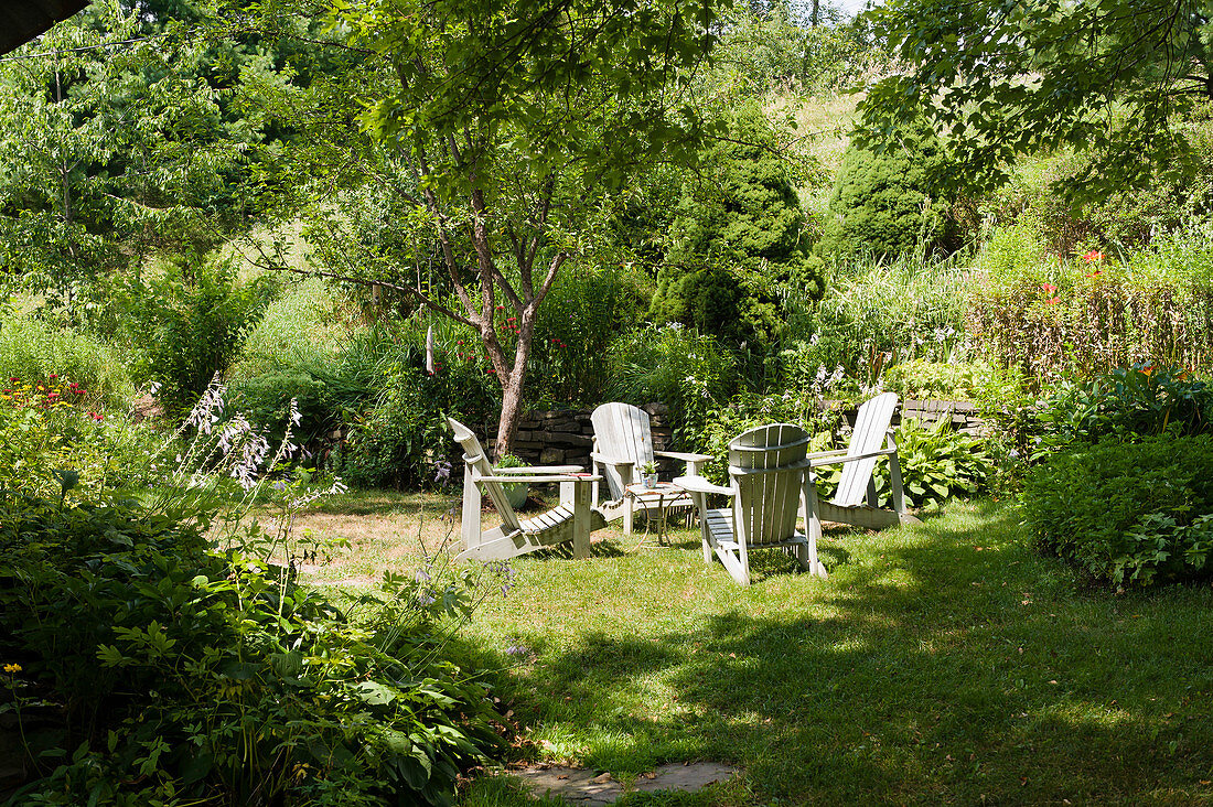 Deckchairs and table on lawn in summery garden