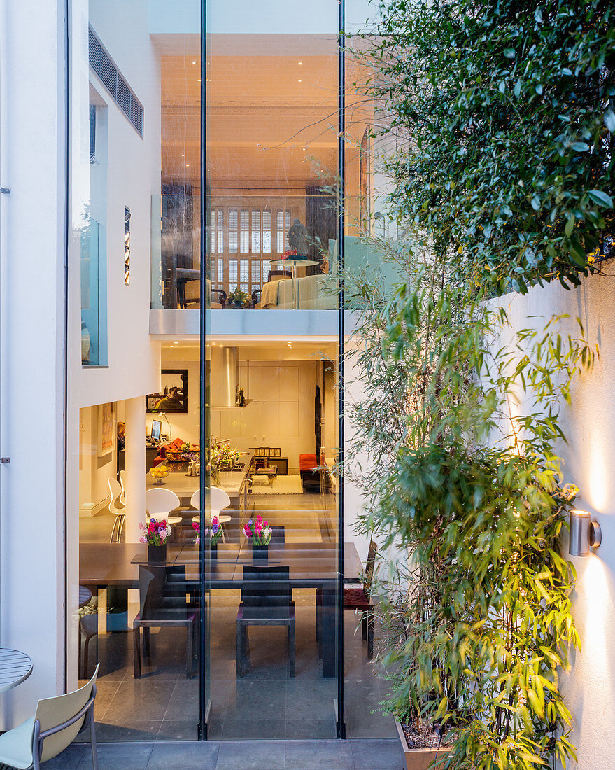 Blick durch haushohe Glasfassade in luxuriöses Stadthaus