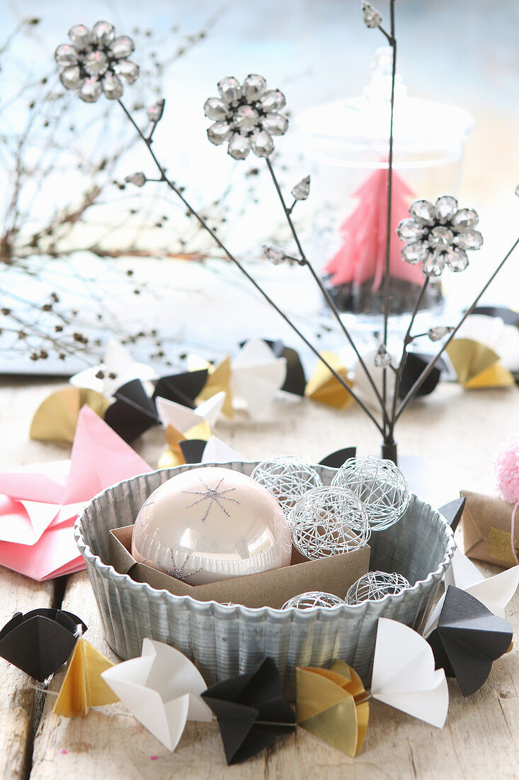 Christmas-tree baubles in cake tin with origami garland