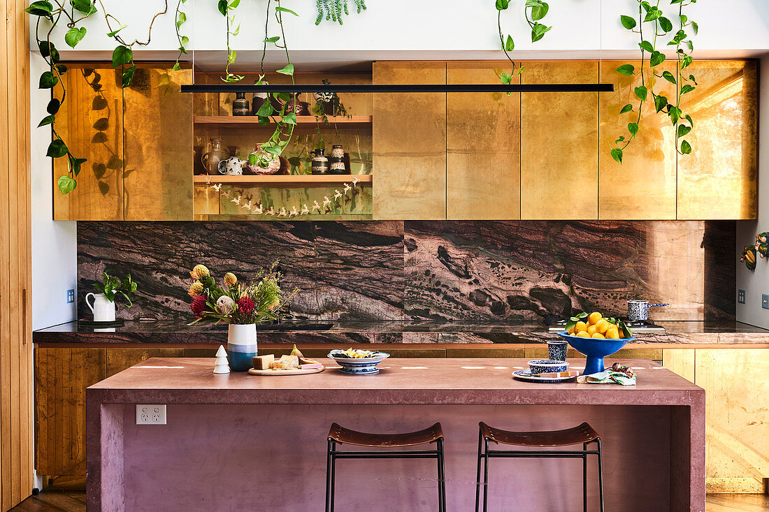 Kitchen with gold-colored fronts and mauve-colored breakfast bar