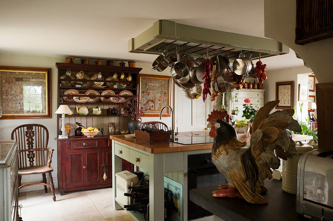 English country-house kitchen with antique dresser and rack suspended over island counter